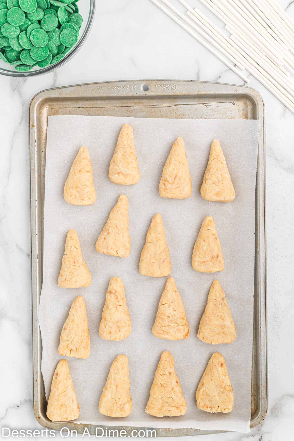 Cake mixture formed into cones on a baking sheet lined with parchment paper