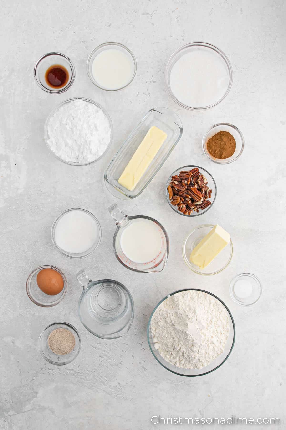 Ingredients needed for Cinnamon Roll - warm water, active dry yeast, milk, melted butter, sugar, salt, egg, flour, cinnamon, sugar, walnuts, powdered sugar, vanilla extract milk