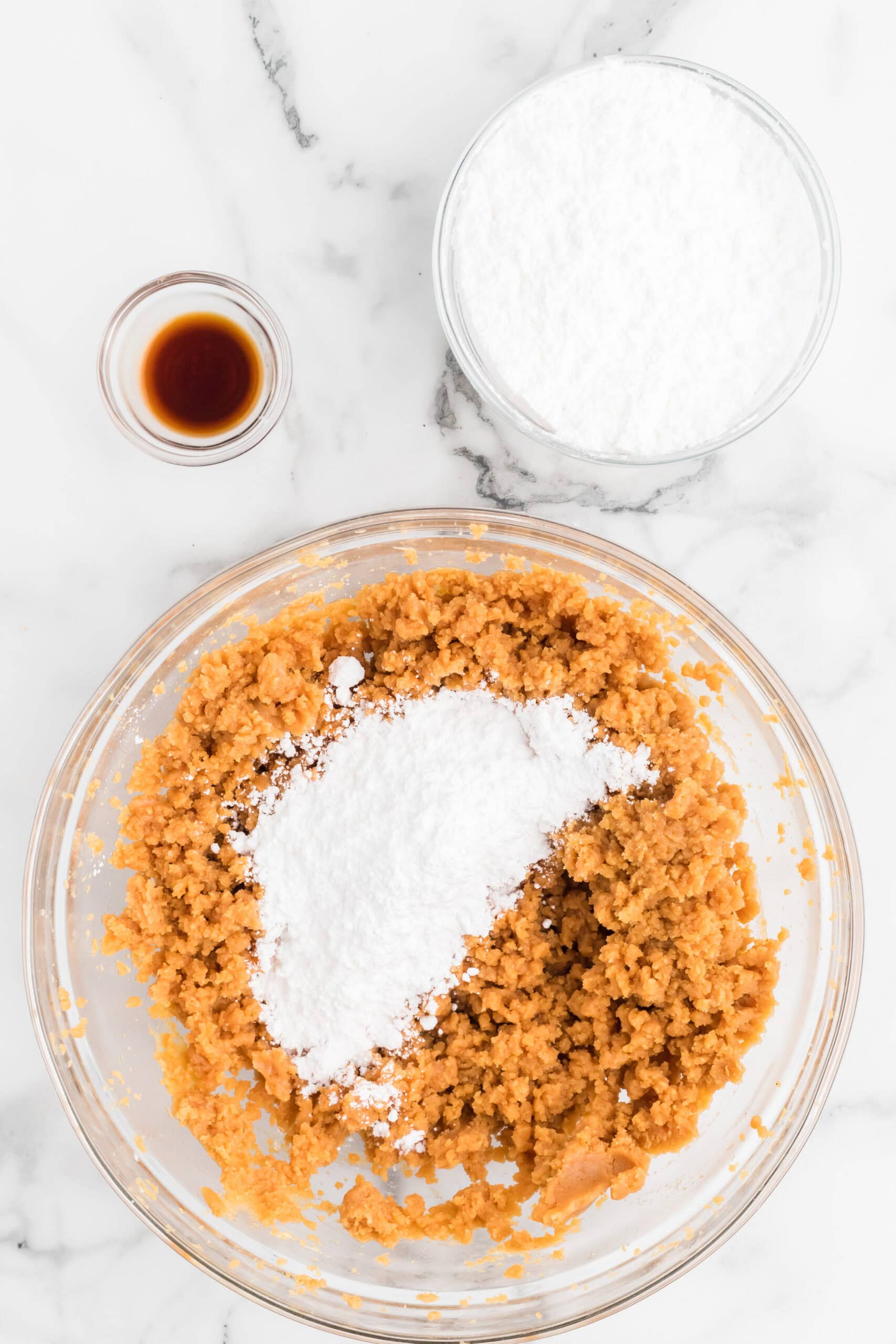 Adding powdered sugar to the peanut butter in a bowl