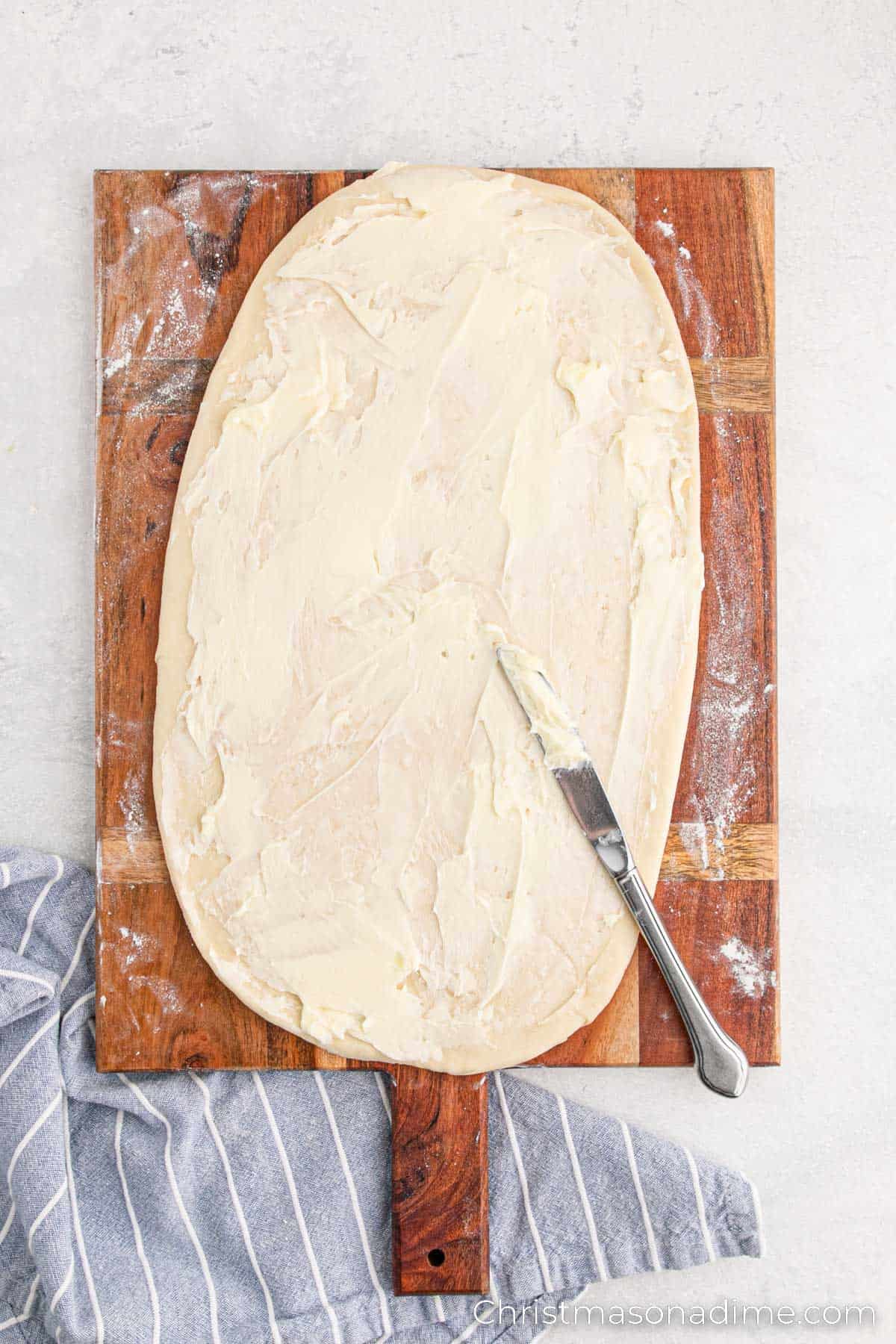 Spreading butter on dough