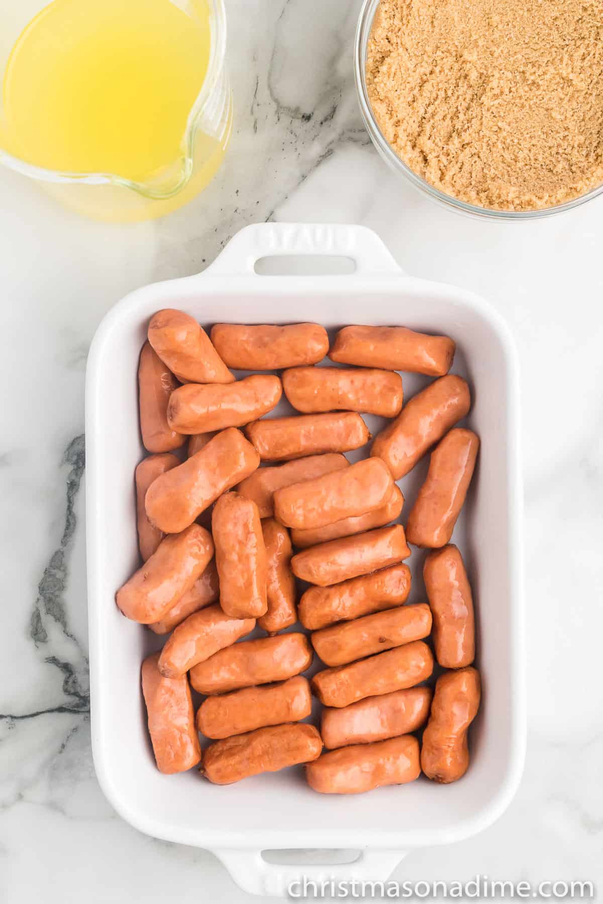 Beanie Weenies in a baking dish with a side of melted butter and brown sugar