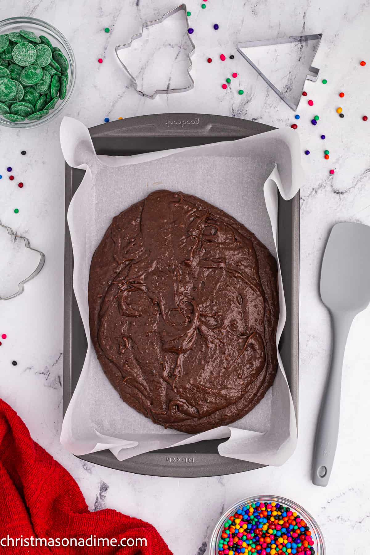 Spread brownie into baking pan lined with parchment paper